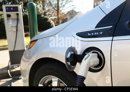 A Chevy Volt electric vehicle being charged at a public charging station in downtown Raleigh, North Carolina, USA Stock Photo