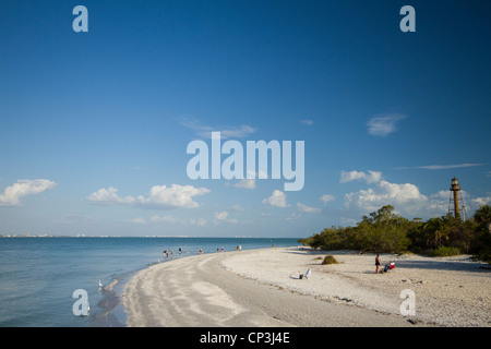 Beach goers at Sanibel Island Florida - lighthouse in the background Stock Photo