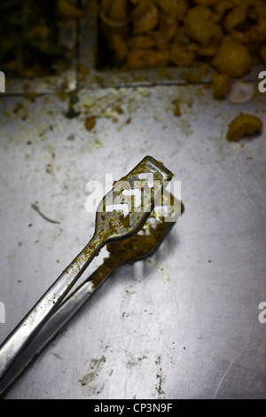 A pair of serving tongs at Sitaram chole bhature wala, Delhi, India Stock Photo