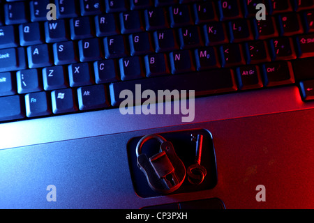 Security . Classic padlock and key with contemporary lighting on keyboard illustrating cyber security . Stock Photo