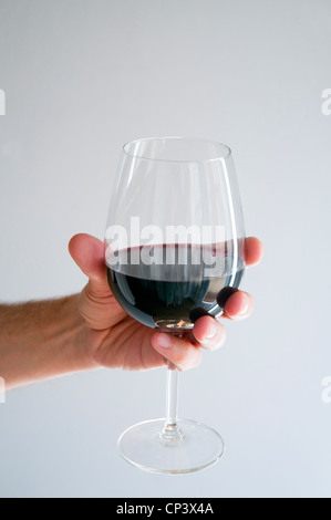 Man's hand holding a glass of red wine. Stock Photo