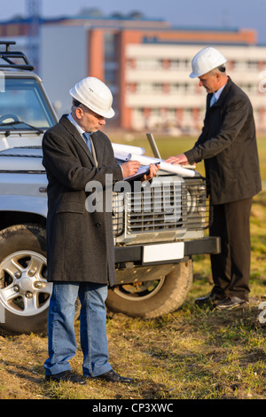 Male architect developers on construction site making notes building project Stock Photo
