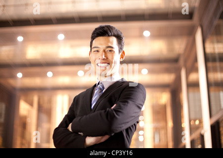 A businessman outside an office building at night Stock Photo