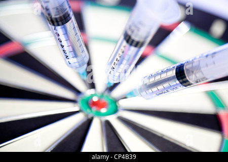 Syringes stuck in a dartboard Stock Photo