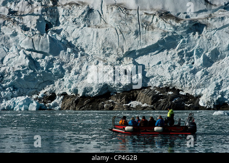 Greenland - West Coast - Tourists in an excursion by rubber boat watching the rocks, covered by ice. Stock Photo