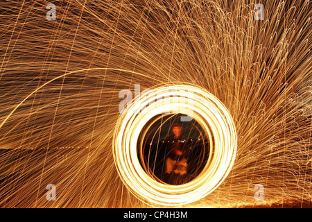 lite steel wool spun creating amazing lines of light and contrast with the night sky Stock Photo