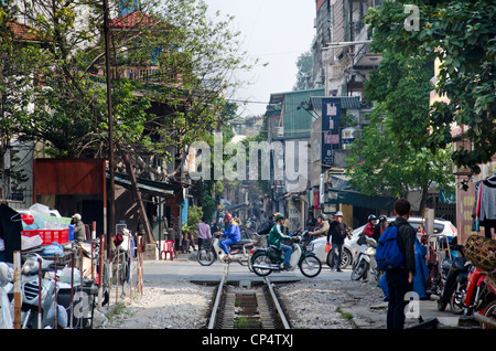 Hanoi intense traffic with motorcycles, cars and pedestrians. Railroad crossing in Old Town. Stock Photo