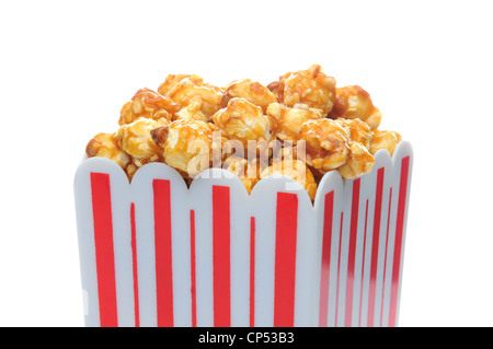 Closeup of caramel corn in a striped container over white. Stock Photo