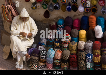 a seller chills out outside his shop trading with artisanal products for sale to tourists, Essaouira, Morocco Stock Photo