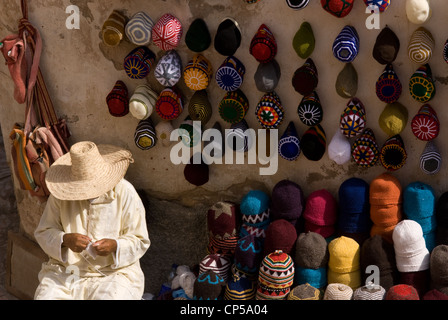 a seller chills out outside his shop trading with artisanal products for sale to tourists, Essaouira, Morocco Stock Photo