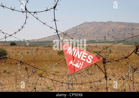 A Syrian minefield in the Golan Heights on the border with Israel, with the listening station of Mount Avital in the background, Al Qunaitra, Syria. Stock Photo