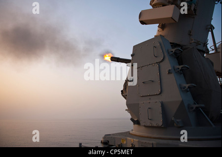 The Ticonderoga-class guided-missile cruiser USS Cape St. George (CG 71) test fires an MK-15 close-in weapon system (CIWS) during a pre-action aim calibration fire exercise. Cape St. George is deployed as part of the Abraham Lincoln Carrier Strike Group to the U.S. 5th Fleet area of responsibility conducting maritime security operations, theater security cooperation efforts and support missions as part of Operation Enduring Freedom. Stock Photo