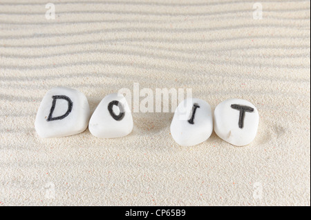 Do it words on group of stones with sand as background Stock Photo