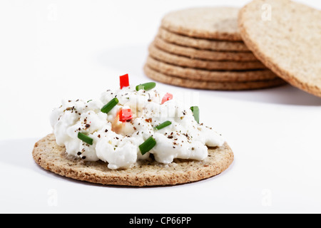 Oatcake topped with cottage cheese garnished with chives,red capsicum and ground pepper Stock Photo