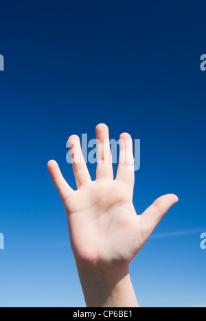 Open hand against a clear blue sky. Stock Photo