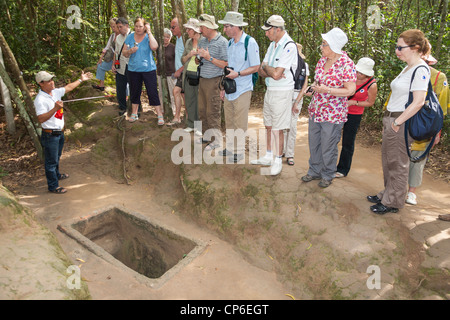 Tourists beside a tunnel entrance at Ben Dinh, Cu Chi, near Ho Chi Minh City, (Saigon), Vietnam Stock Photo