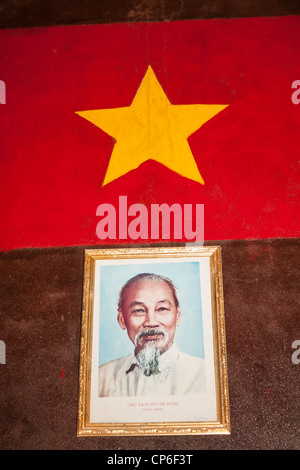 Ho Chi Minh portrait beneath Vietnamese flag, Ben Dinh, Cu Chi, near Ho Chi Minh City, (Saigon), Vietnam Stock Photo