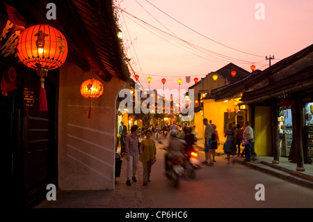 Horizontal cityscape along a traditional road in Hoi An decorated with lanterns lit up at night during sunset. Stock Photo