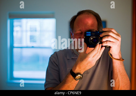 Portrait of a middle aged male photographer reflected in a mirror Stock Photo