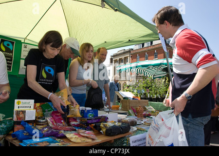 Volunteers promoting fair trade products on a market stall in Devizes, Wiltshire Stock Photo