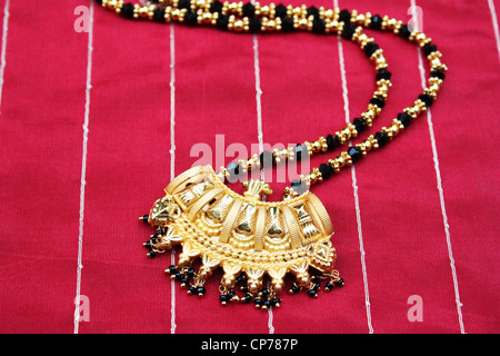Traditional Indian gold jewelry on red silk fabric Stock Photo