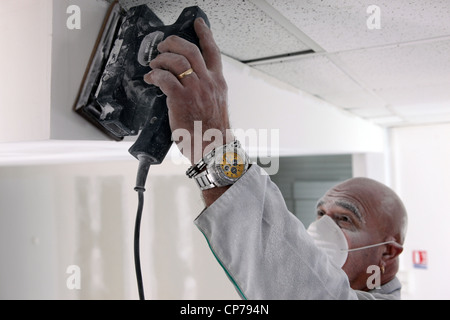 Man sanding plasterboard Stock Photo