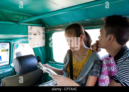 People riding a jeepney, a form of public transport. Lapu-Lapu City, Metro Cebu, Mactan Island, Visayas, Philippines. Stock Photo