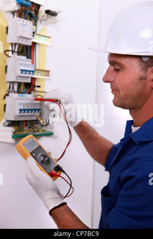 Electrician inspecting fuse box Stock Photo