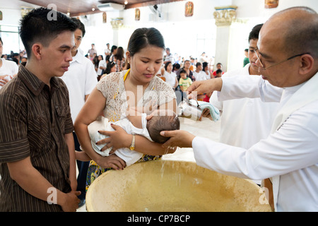 Lapu-Lapu City, Philippines, 26/02/2012: 200-300 babies being baptised in a single 3 hour ceremony at Mactan Air Base Chapel. Stock Photo