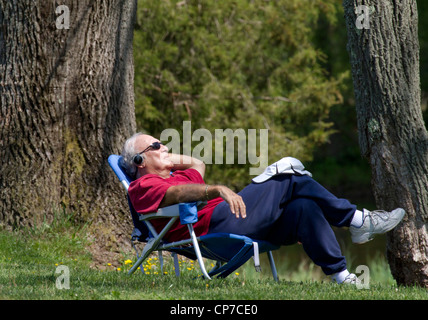 A senior man asleep in a lawn chair. Stock Photo