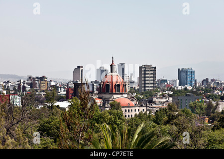 view of Mexico City skyline on spring day looking South from Chapultepec hill over treetops of Chapultepec park Mexico City Stock Photo