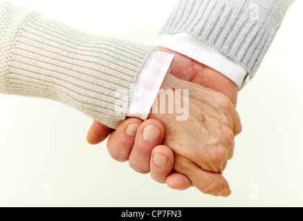 Seniors holding hands indicating their commitment to each other Stock Photo