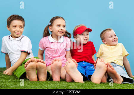 Four young little barefoot pretty smiling girls playing together on ...