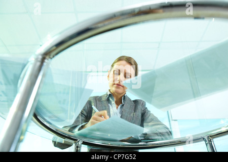 Image of formal businesswoman making notes on paper at workplace Stock Photo