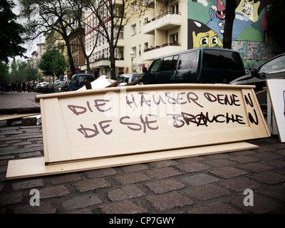Makeshift roadblock by squatters in Berlin-Kreuzberg, Germany. The writing reads: 'Houses for those who need them' Stock Photo