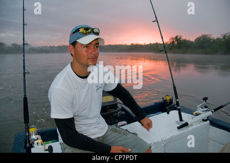 A Nicaraguan guide trolls a crankbait for tarpon on the Rio San Juan near the town of Sabalos below Lake Nicaragua. Stock Photo