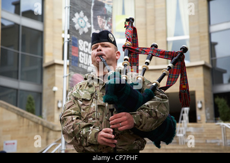 piper from the scots guards playing at an army recruiting stand in glasgow city centre Scotland UK Stock Photo