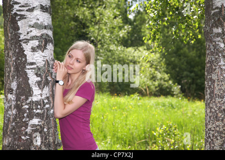 girl at a birch in forest the spring afternoon Stock Photo