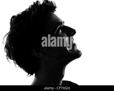 young man looking up smiling happy portrait silhouette in studio isolated on white background Stock Photo