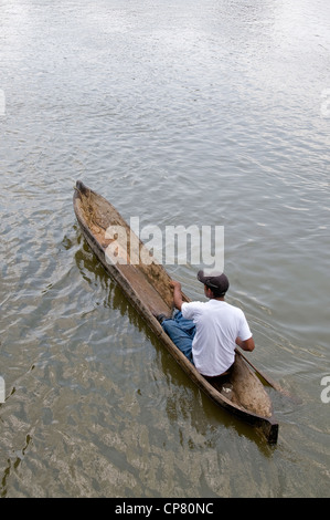 A Nicaraguan man paddles his tiny dugout boat down the Rio San Juan near the town of Sabalos below Lake Nicaragua. Stock Photo