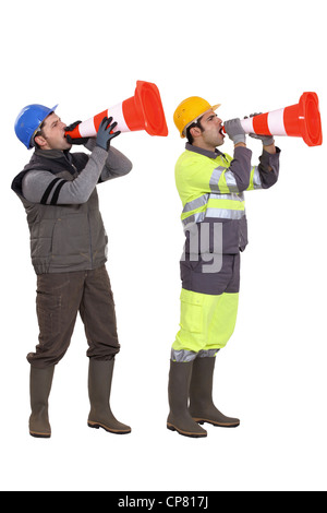 Men using traffic cones as loudspeakers Stock Photo