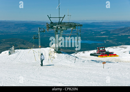 Snowboarder arriving at the top station on the Cairngorm Mountain ski resort  in Speyside Scotland on a May day with ample snow Stock Photo