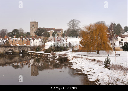 Snow bound village in Kent Aylesford with a Medieval bridge over calm tidal River Medway reflection showing tranquil atmosphere Stock Photo