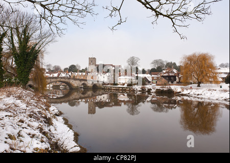 Snow bound village in Kent Aylesford with a Medieval bridge over calm tidal River Medway reflection showing tranquil atmosphere Stock Photo