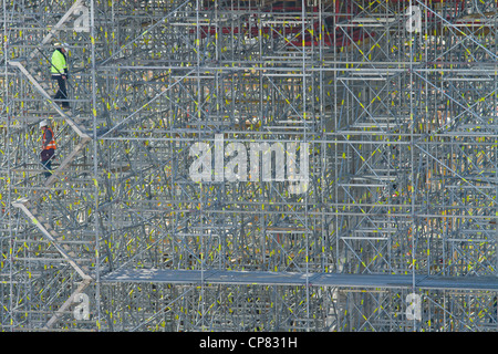 Two workers on huge scaffolding at work site of Katowice railway station. Poland. Stock Photo