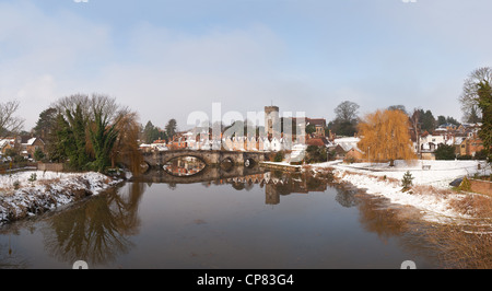 Snow bound village in Kent Aylesford with a Medieval bridge over calm tidal River Medway reflection showing tranquil atmosphere Stock Photo