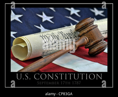 United States Constitution with wooden judge's gavel, and American flag background. Stock Photo