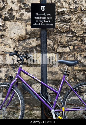 Bicycle chained to a 'Please do not park bikes sign post', Oxford, Oxfordshire, England Stock Photo