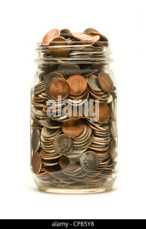 Glass jar almost overflowing with American coins against a white background Stock Photo