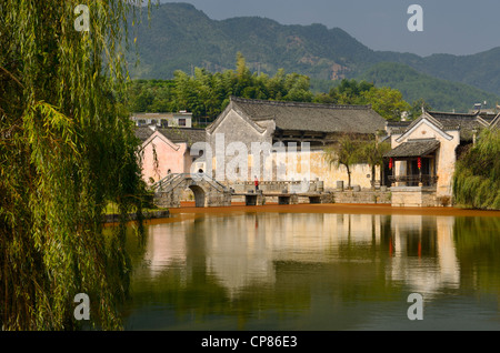 Willow trees on the Longxi river with ancient bridge and Hui houses in Chengkan Huangshan Peoples Republic of China Stock Photo